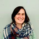Portrait of Doriane Guennoc, a smiling brown-haired woman with a green jumper