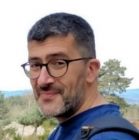 Portrait of Sébastien Carcelle, a man with short hair, beard and glasses